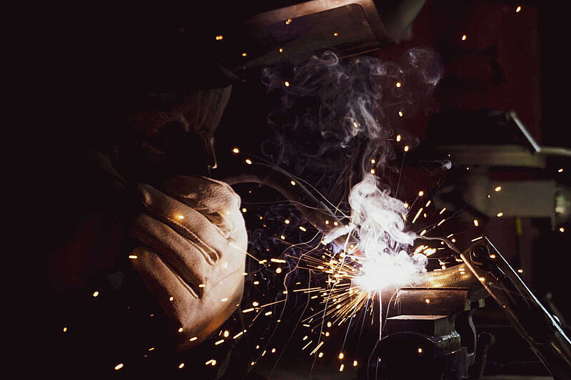 welder working on a piece of metal with sparks